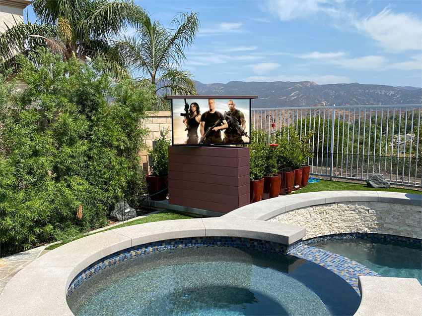 Outdoor TV Lift in composite decking next to Pool and spa