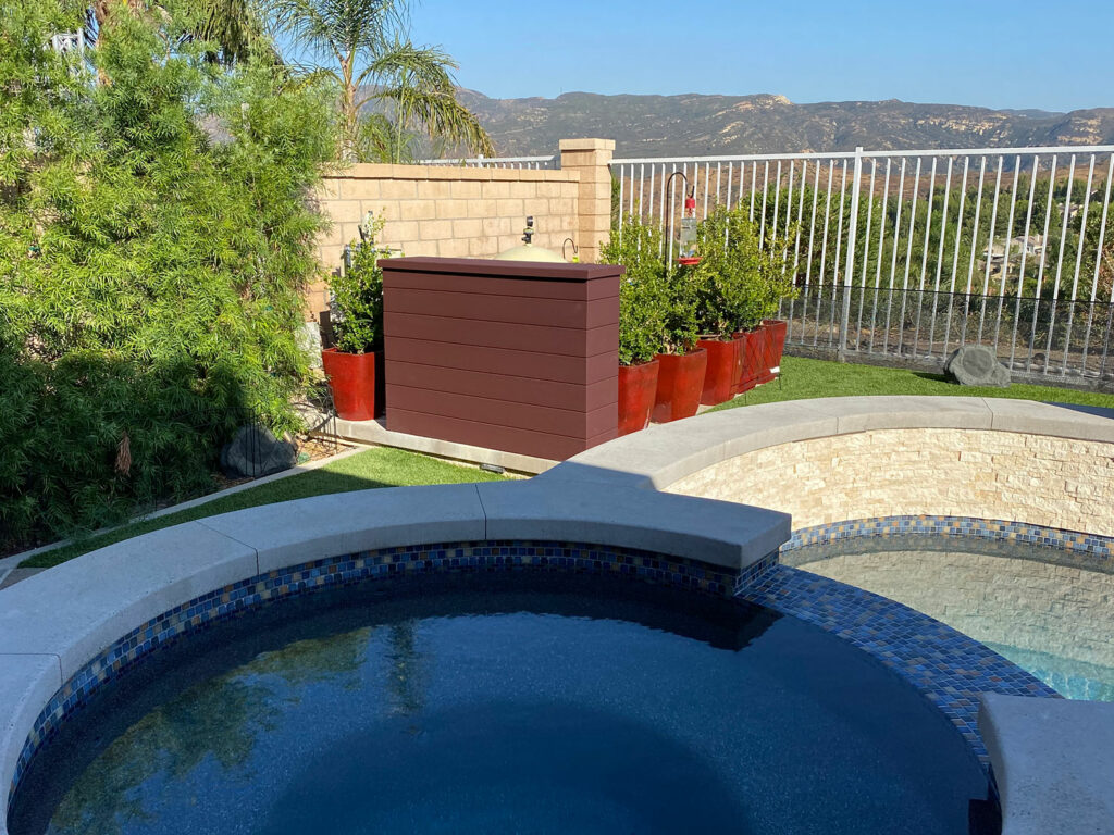 Composite decking outdoor TV lift installed next to pool and spa