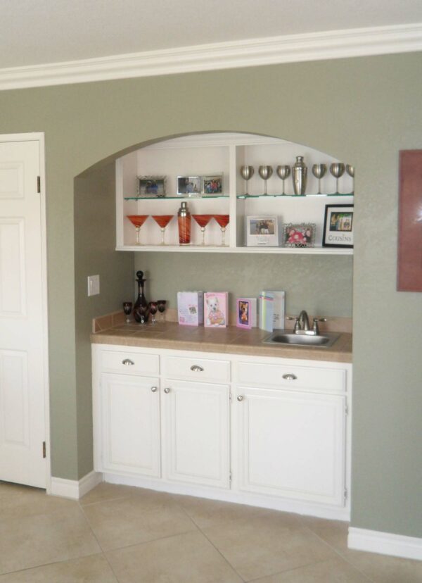 We built a custom wet bar unit on an adjacent wall in a matching style and white finish