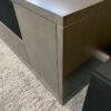 Close-up view of the simple and clean styling of this gray credenza with a V-groove detail