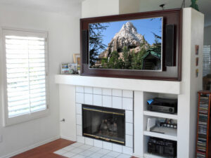 Custom back wall above fireplace for a large flat panel TV and two on-wall speakers