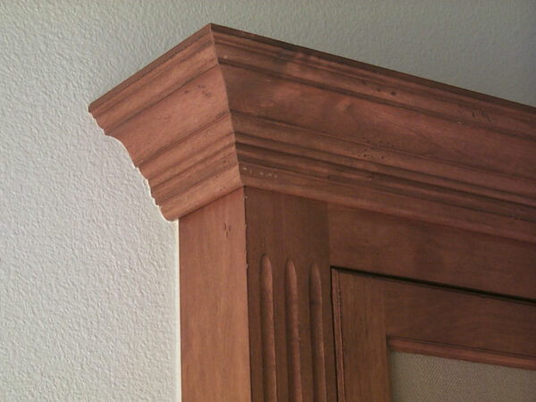 Traditional decorative crown molding with fluted face frame. Distressed finish.
