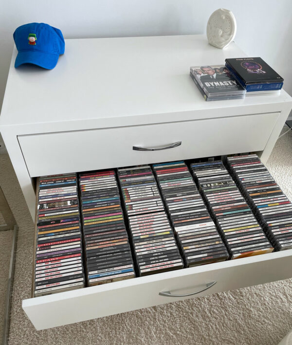 Open view of CD storage drawer, six rows of CDs organized side by side