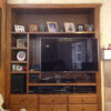 This picture shows the honey oak wall unit before it was modified. The TV was off centered and hung awkwardly.