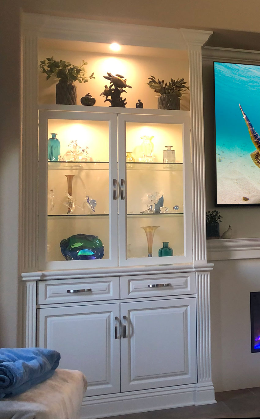 Closeup view of custom display cabinet with lighted display space and glass shelves.